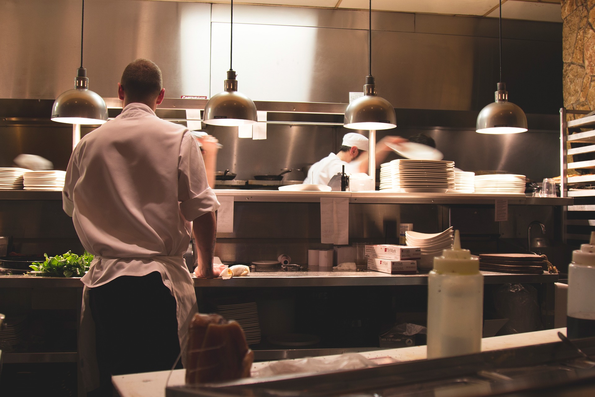 Bilden visar ett restaurangkök eller ett storkök. Restaurangmaskiner behövs i moderna kök för att hålla produktiviteten uppe och för att tillaga mat av högsta kvalitet.
